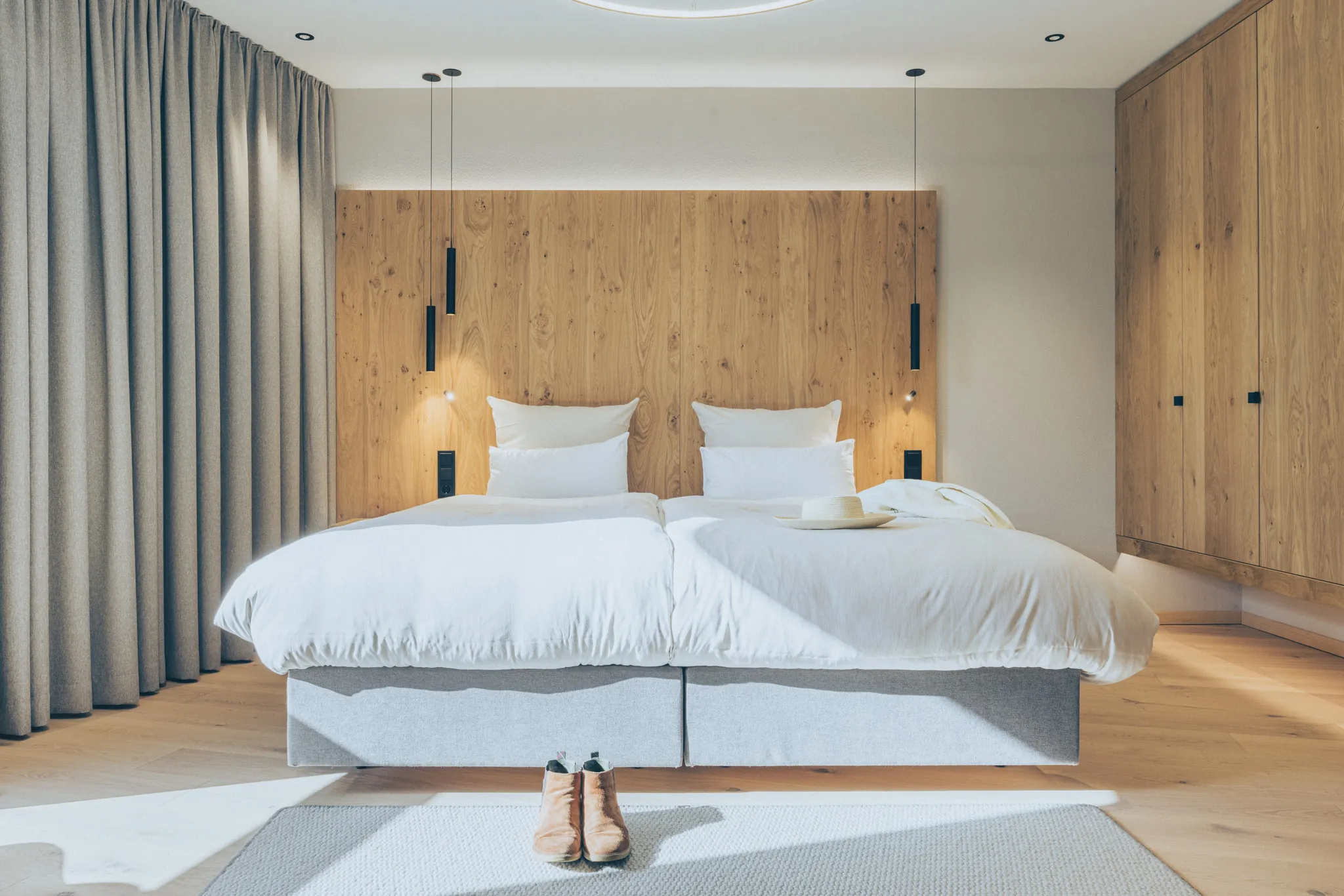 Helles Schlafzimmer mit Holzwand und Doppelbett im DAS GERLOS