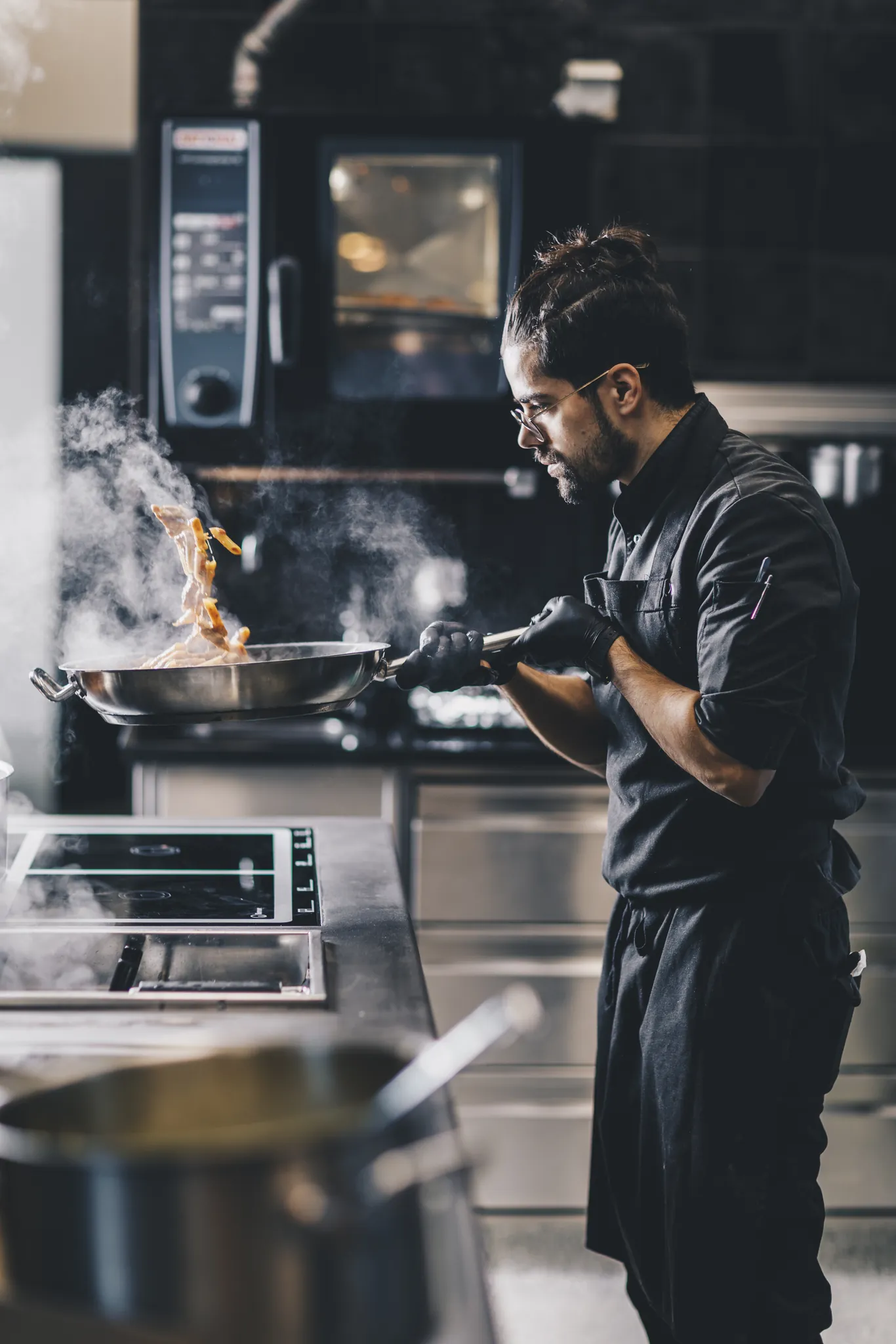 Koch flambiert in der Pfanne, Flammen schlagen hoch, Restaurant 23 Reasons
