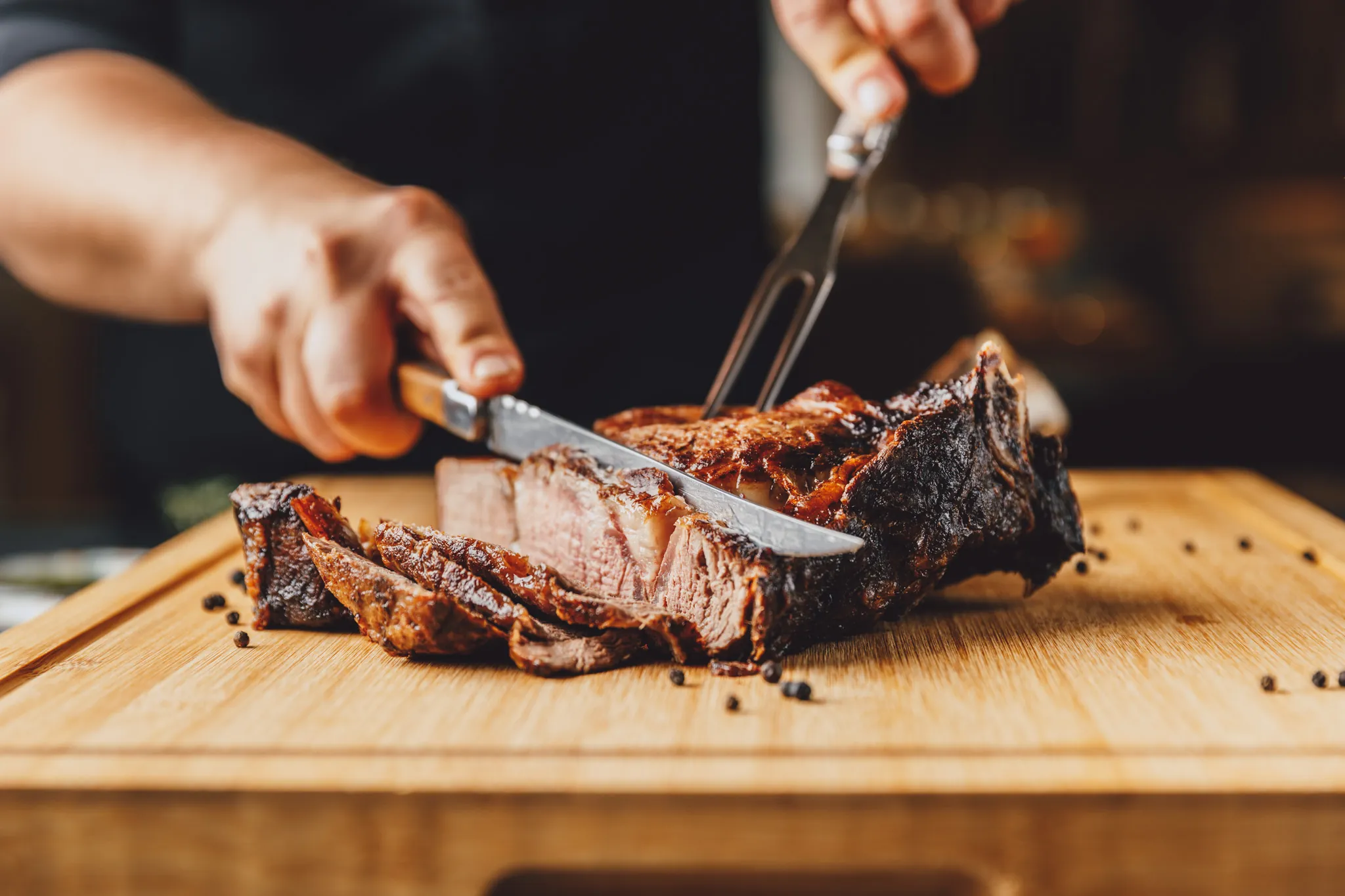 Steak wird auf dem Holzbrett aufgeschnitten, Das Brixx