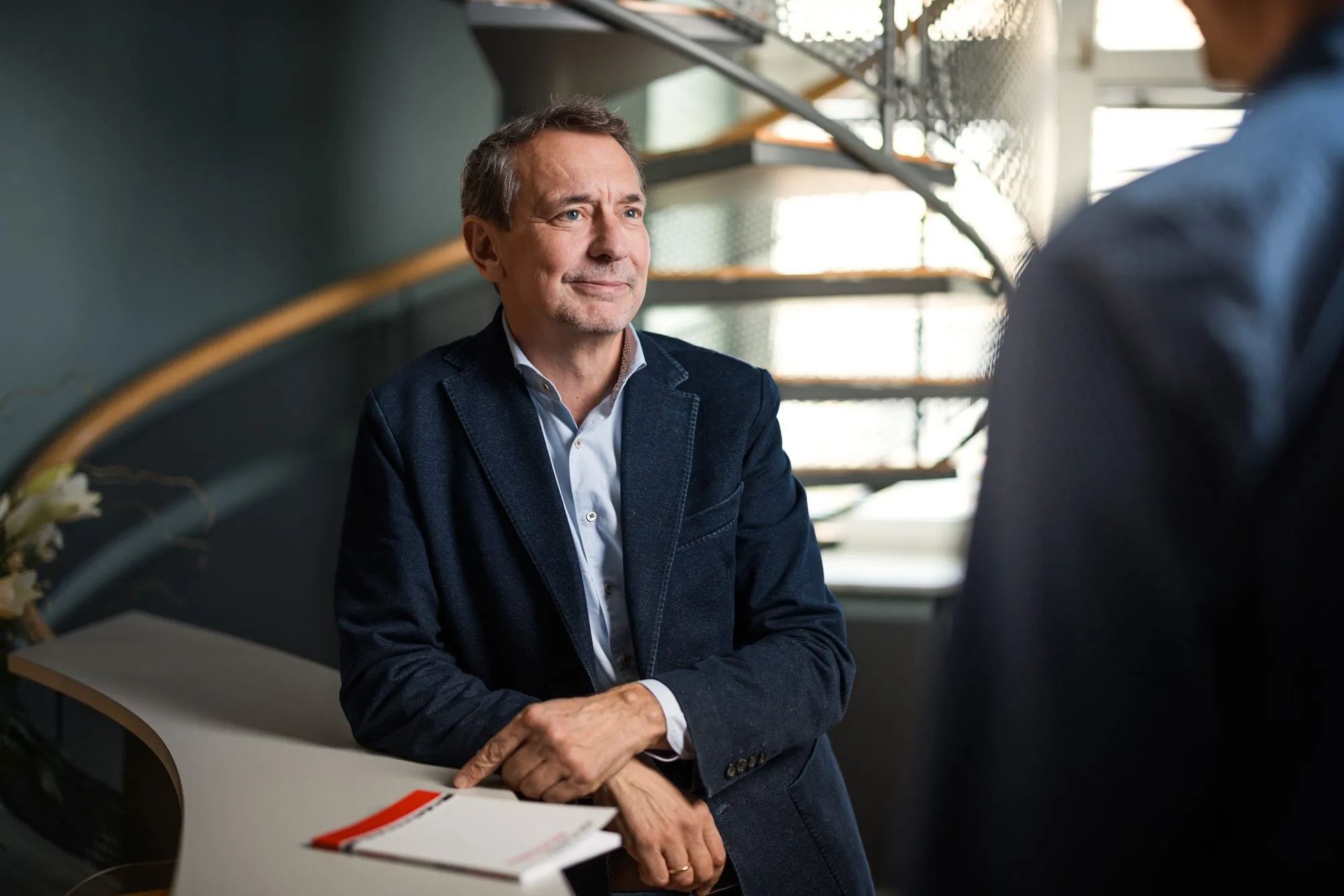 Partner im Gespräch an der Wendeltreppe der Kanzlei