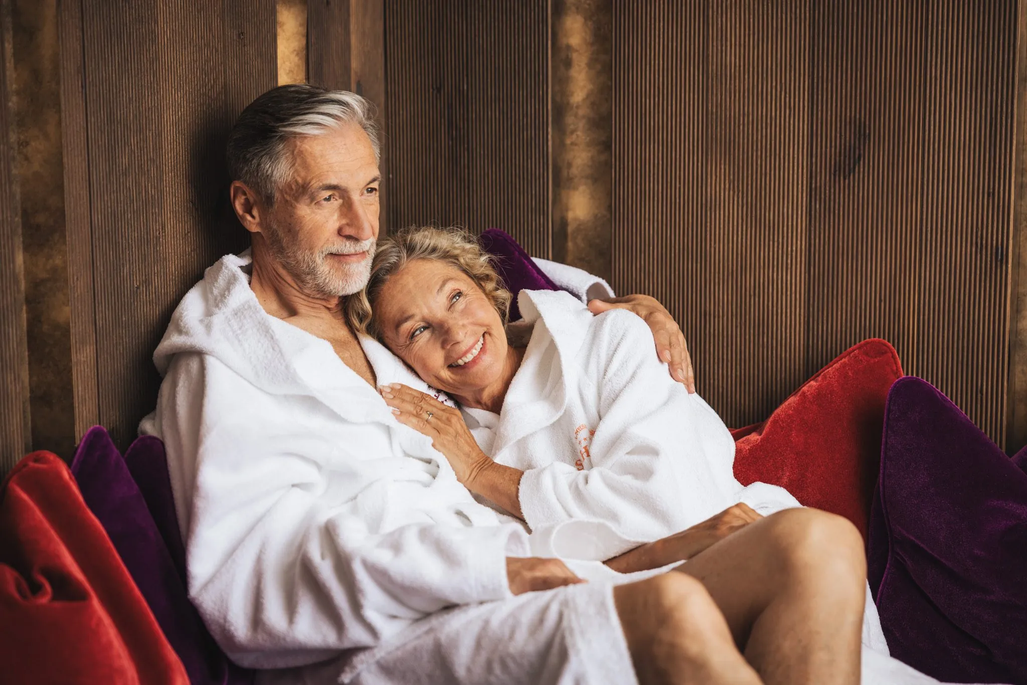 Paar entspannt auf der roten Spa-Lounge in der Wellnessresidenz Schalber