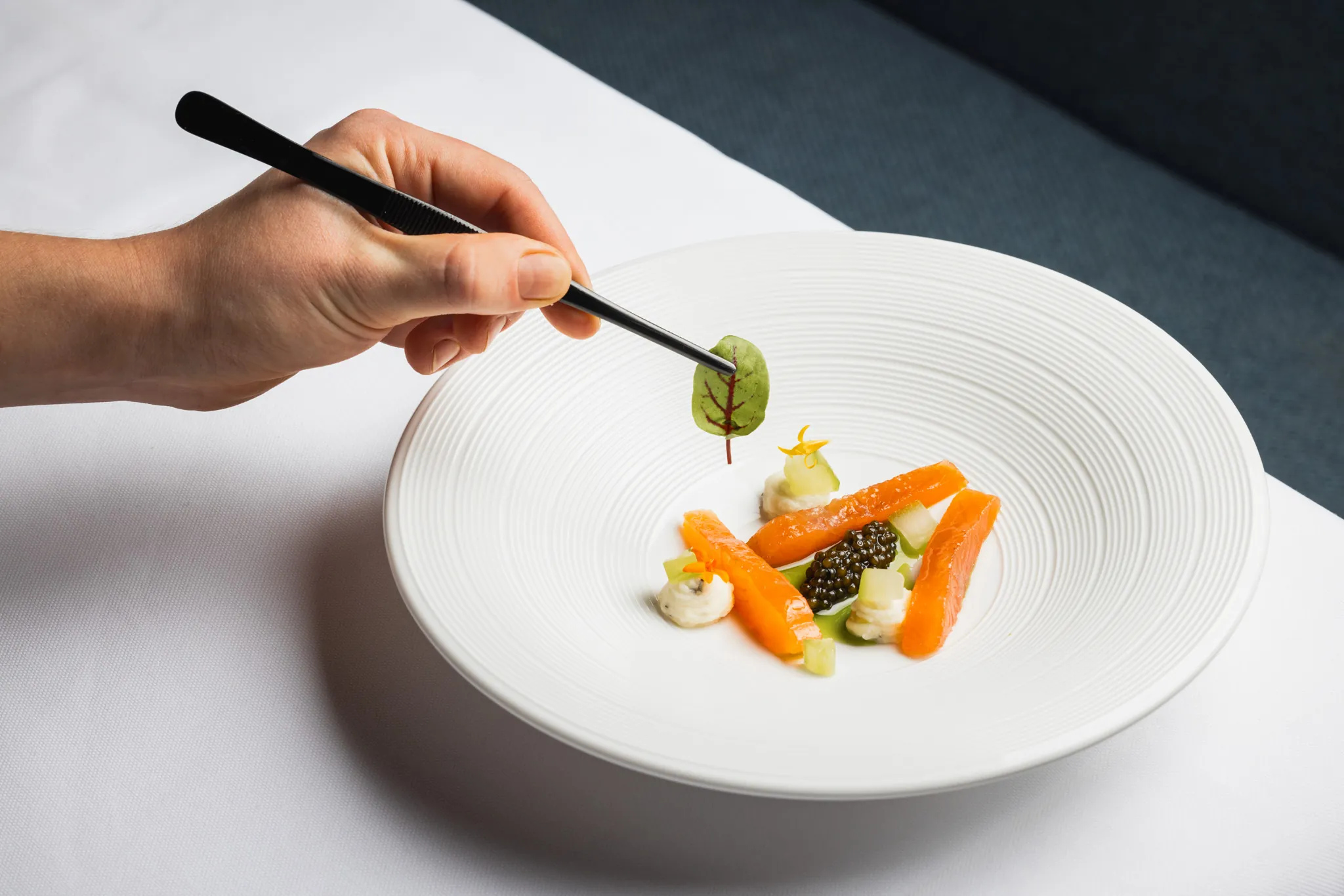 Koch richtet Lachs mit Kaviar mit der Pinzette an, Stanglwirt
